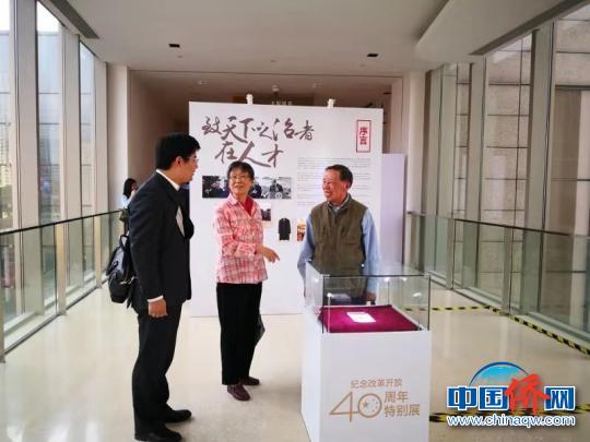 展品提供者(右一)与参观者交流。　朱勇文 摄