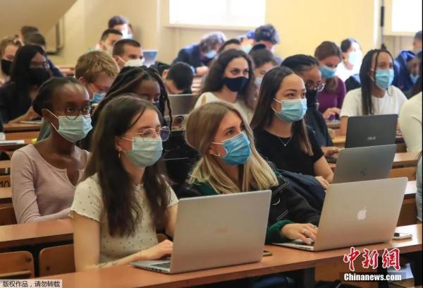 资料图：巴黎一所大学的学生戴口罩上课。