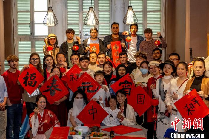 2月4日，40多位国际友人来到海口骑楼老街体验喜庆中国年。图为国际友人展示书法作品。　蒋聚荣摄