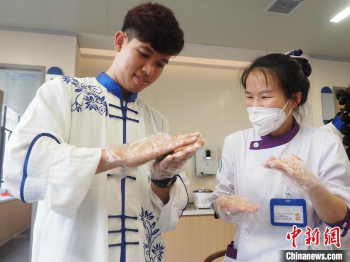 中国侨网图为一名留学生在学习制作青团。　李娇阳　摄