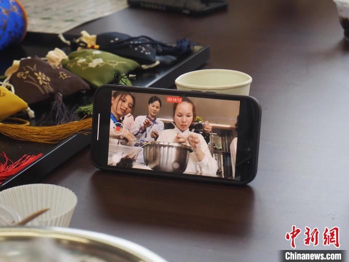 图为留学生用手机将自己制作青团的过程记录下来。　李娇阳摄